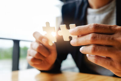 Person holding two pieces of jigsaw